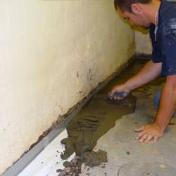 A basement waterproofer installing a perimeter drain system in Columbus