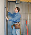Insulated basement wall panels being placed against a concrete foundation wall in Jamestown